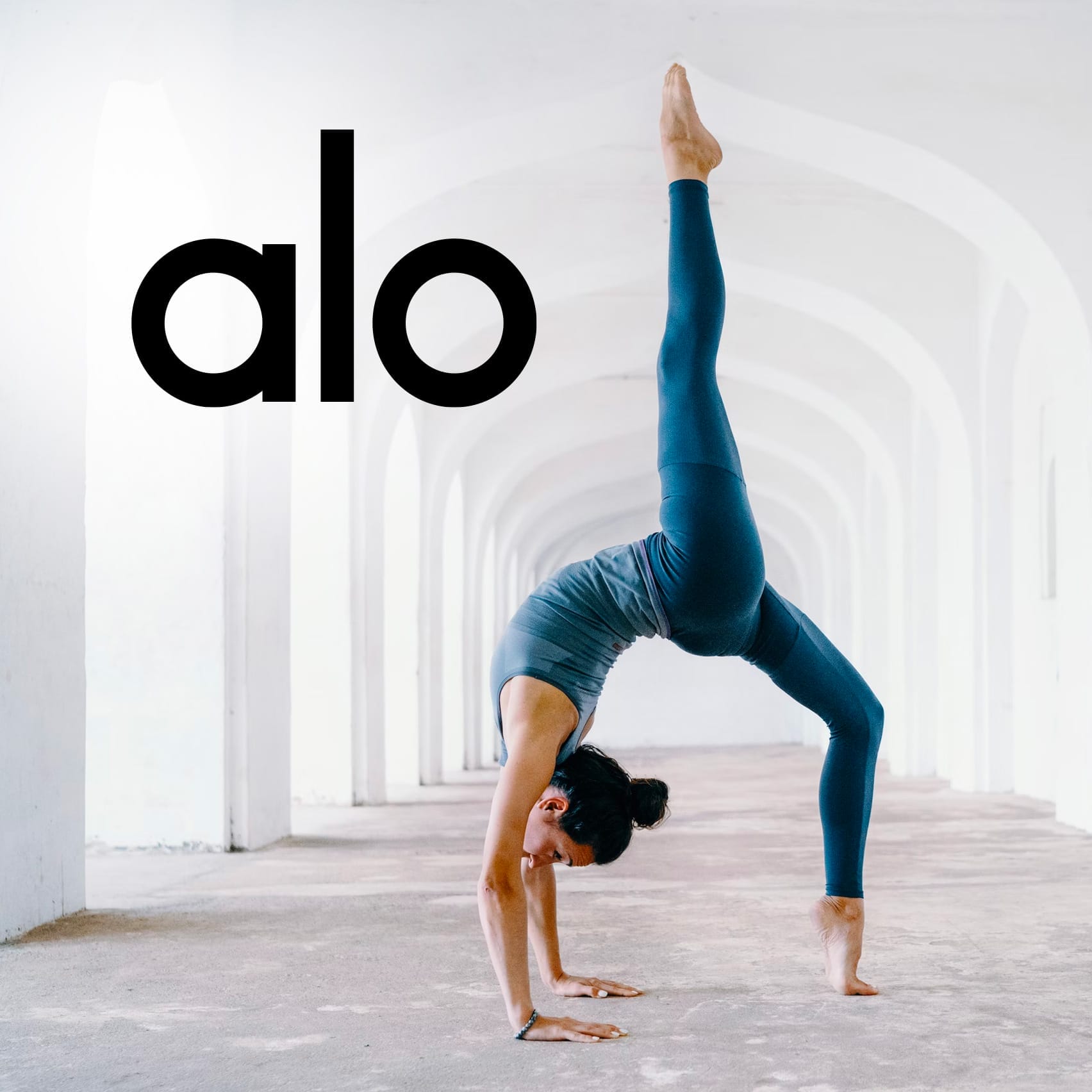 A woman doing Alo Yoga in an archway with the word ola.